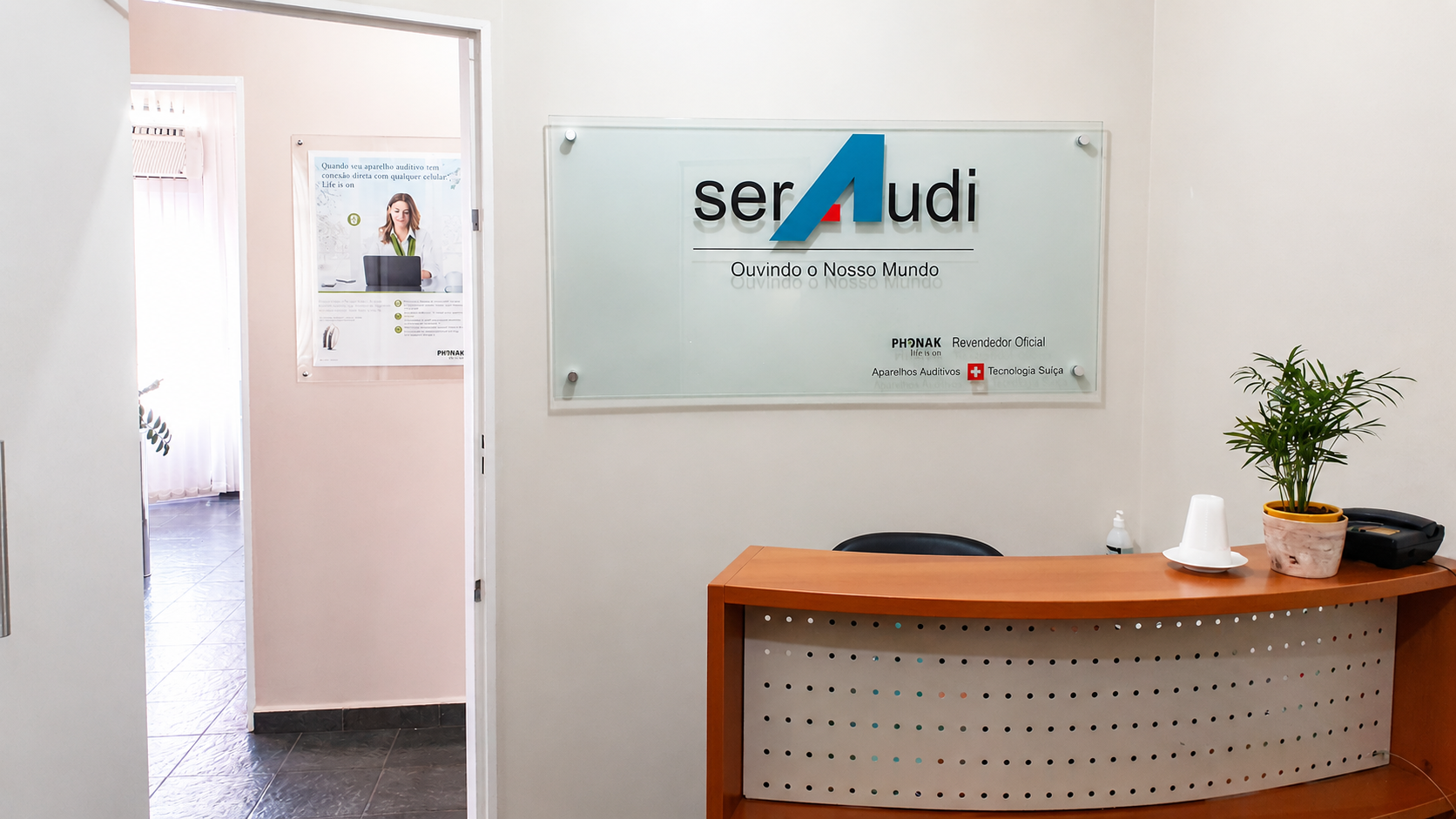 Recepção da SerAudi São Carlos com identificação da clínica e revenda oficial Phonak